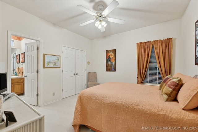 carpeted bedroom with ceiling fan, ensuite bath, and a closet