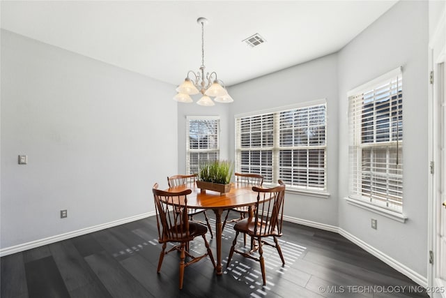 dining area with a notable chandelier and dark hardwood / wood-style floors