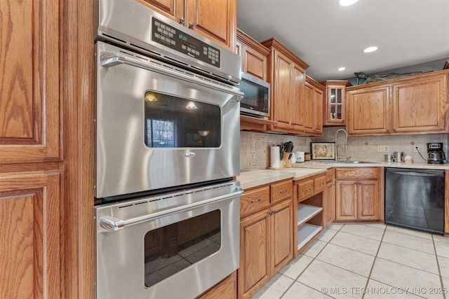 kitchen featuring sink, light tile patterned floors, decorative backsplash, and appliances with stainless steel finishes