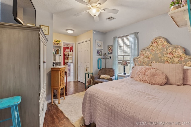 bedroom with dark hardwood / wood-style floors, ceiling fan, and a closet