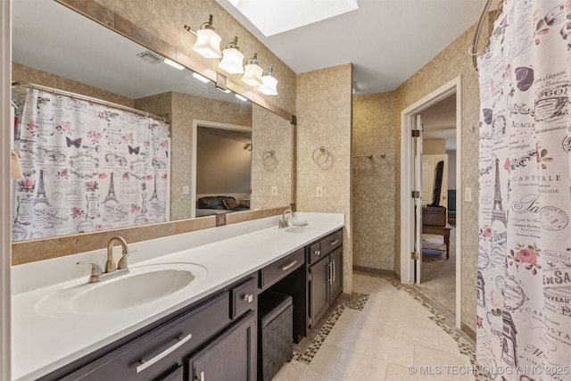 bathroom with vanity, tile patterned floors, and a skylight