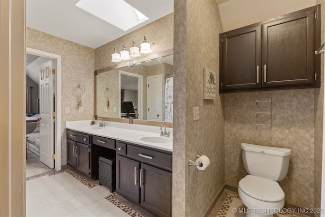 bathroom featuring vanity, a skylight, and toilet