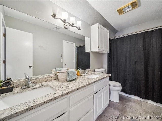 bathroom featuring vanity, a textured ceiling, tile patterned floors, and toilet