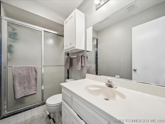 bathroom featuring vanity, walk in shower, tile patterned floors, and toilet