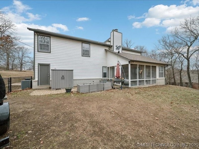 back of property with a yard and a sunroom