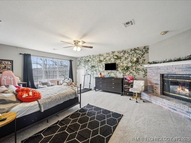 carpeted bedroom featuring ceiling fan, a fireplace, and a textured ceiling