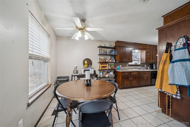 dining space featuring sink, light tile patterned floors, a textured ceiling, and ceiling fan