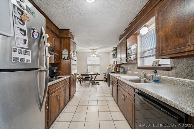 kitchen featuring light tile patterned flooring, sink, a textured ceiling, stainless steel appliances, and decorative backsplash