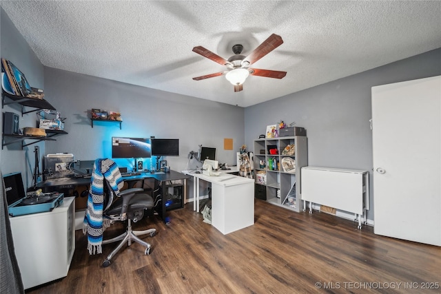 home office with dark wood-type flooring, ceiling fan, and a textured ceiling