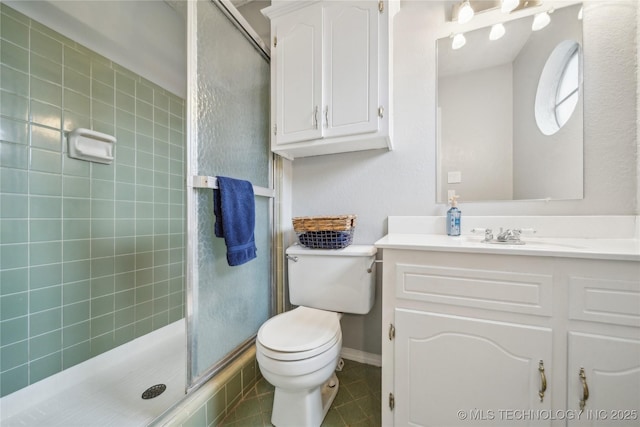 bathroom featuring tile patterned flooring, vanity, a shower with door, and toilet