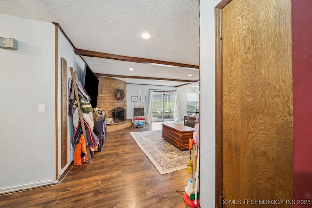 hallway with beamed ceiling, dark hardwood / wood-style flooring, and a textured ceiling