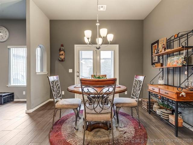 dining room with an inviting chandelier and dark hardwood / wood-style flooring