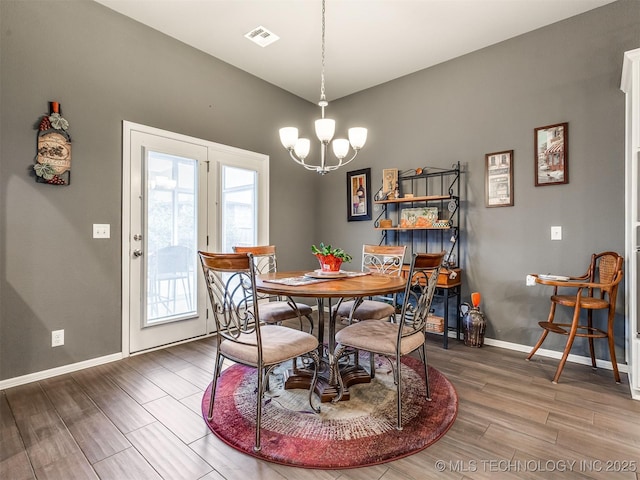 dining area with hardwood / wood-style flooring and a chandelier