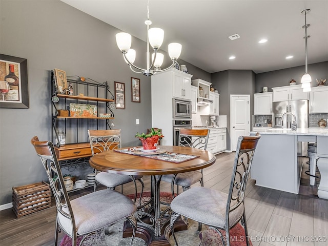 dining space with a chandelier and hardwood / wood-style floors