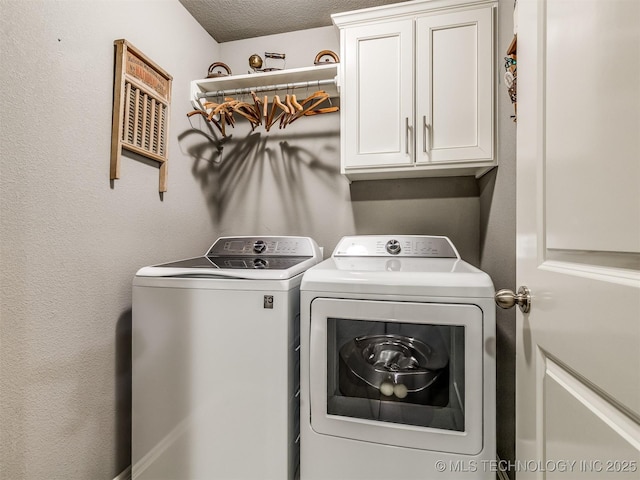 laundry area with cabinets, independent washer and dryer, and a textured ceiling