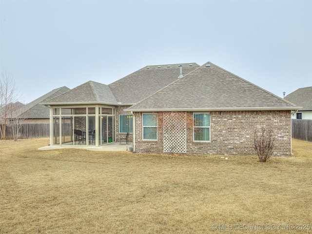 rear view of property with a patio area, a sunroom, and a lawn