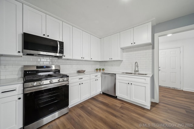 kitchen with appliances with stainless steel finishes, sink, white cabinets, and dark hardwood / wood-style flooring