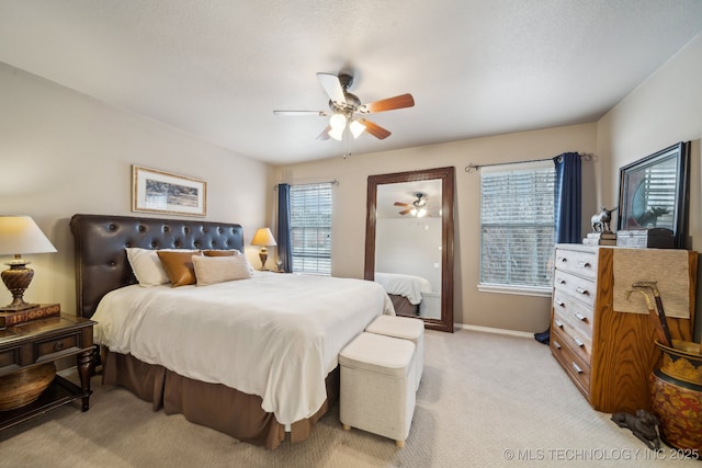 bedroom with ceiling fan and light carpet