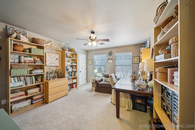 office space featuring ceiling fan, light carpet, and a textured ceiling