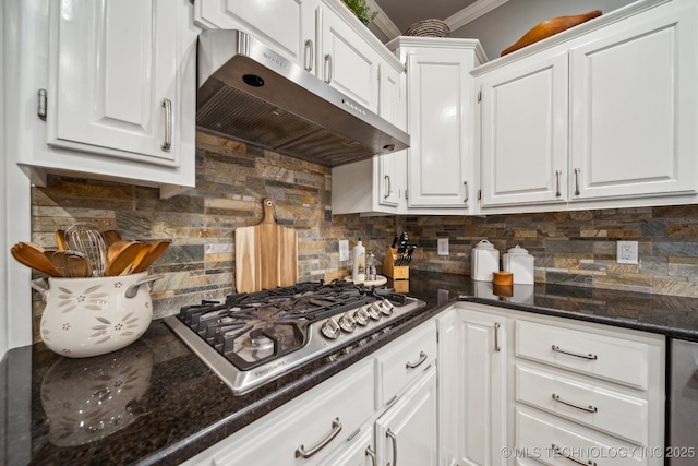 kitchen featuring dark stone countertops, stainless steel gas stovetop, decorative backsplash, and white cabinets