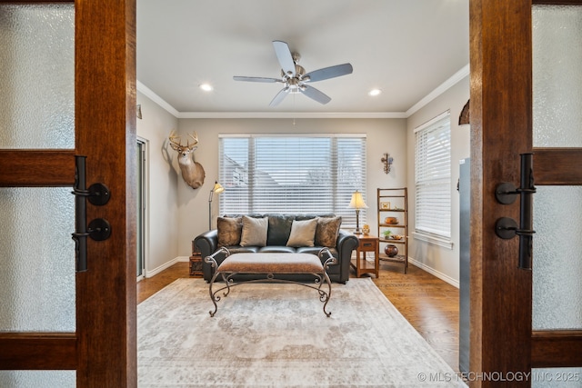 living room featuring crown molding, plenty of natural light, and wood-type flooring