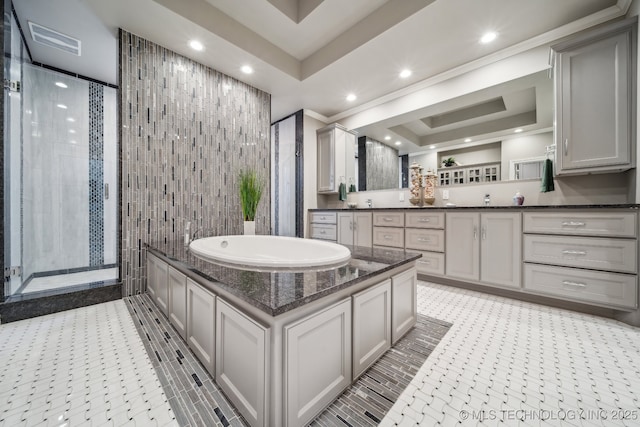 bathroom with vanity, a tray ceiling, tile walls, and shower with separate bathtub