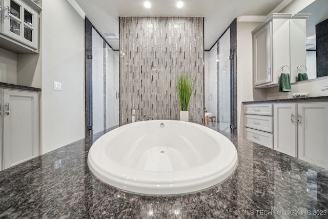 bathroom featuring tile walls, vanity, and independent shower and bath