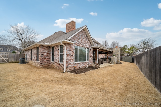 view of side of home with a yard, central AC, and a patio