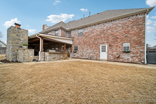 rear view of house featuring a bar, a lawn, and central air condition unit