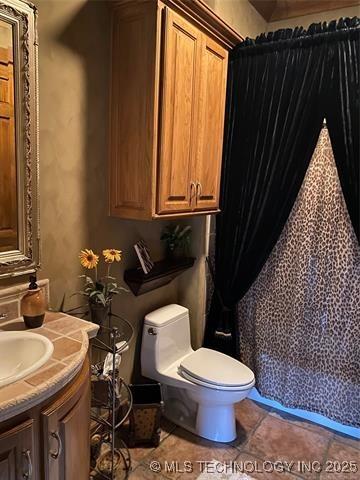 bathroom with vanity, tile patterned flooring, and toilet