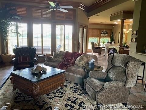 living room featuring ceiling fan, ornamental molding, and ornate columns