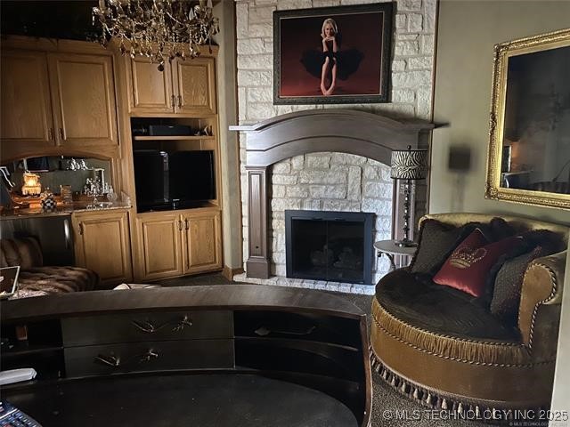 interior space with an inviting chandelier and a stone fireplace