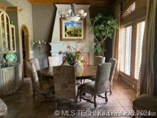 dining space featuring tile patterned flooring and a chandelier