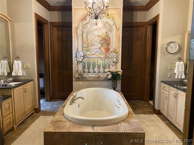 bathroom featuring vanity and tiled bath