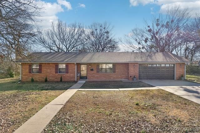 ranch-style house featuring a garage and a front yard