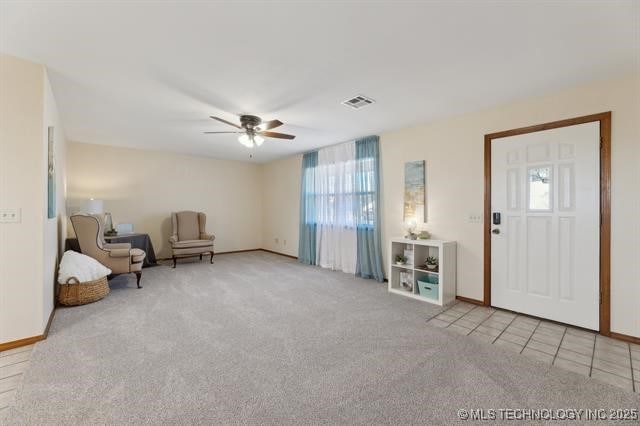 foyer with light colored carpet and ceiling fan