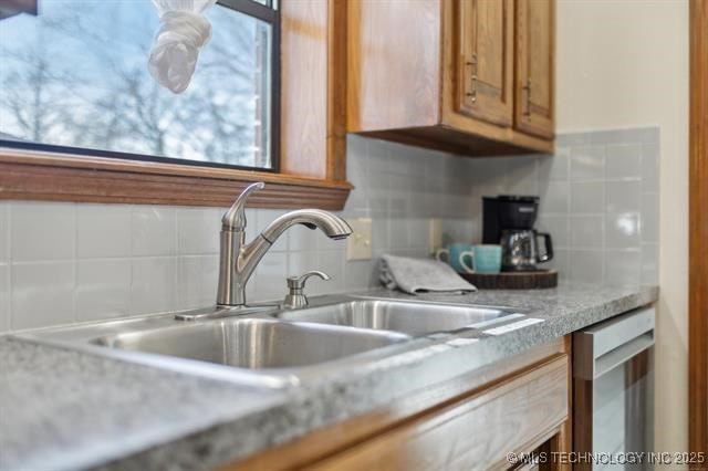 kitchen featuring dishwasher, sink, and decorative backsplash