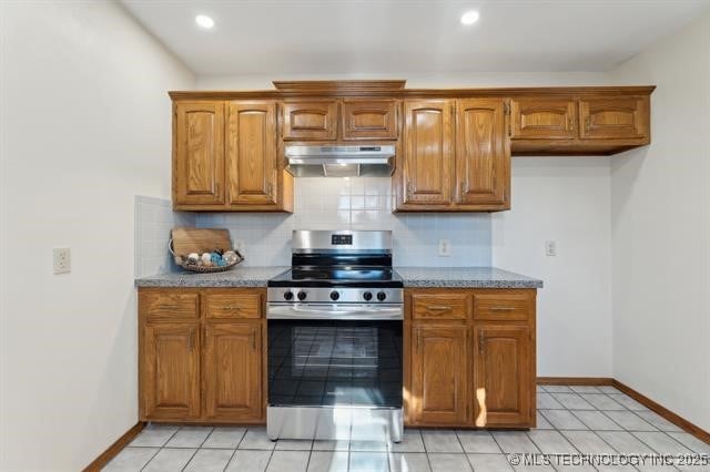 kitchen with electric stove, decorative backsplash, and light tile patterned floors