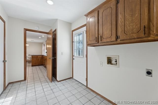 washroom with cabinets, light tile patterned flooring, washer hookup, and hookup for an electric dryer