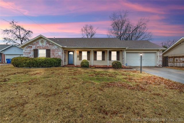 ranch-style home featuring a garage and a lawn