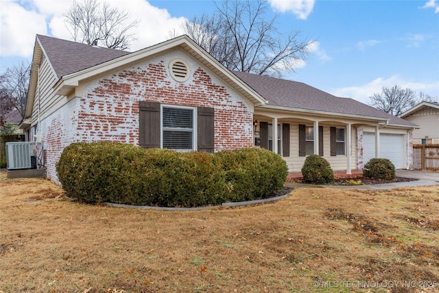 view of front facade with cooling unit, a garage, covered porch, and a front lawn