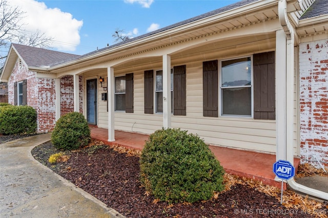 view of exterior entry featuring covered porch