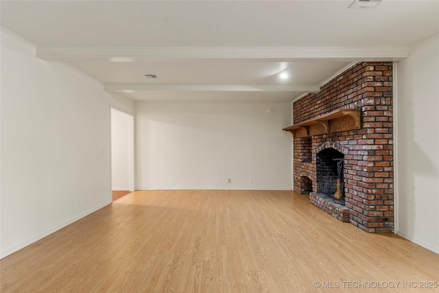 unfurnished living room featuring beamed ceiling, a fireplace, and light hardwood / wood-style flooring