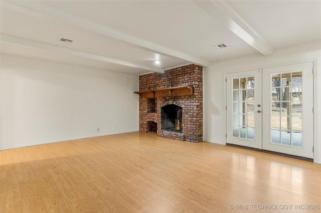 unfurnished living room featuring a brick fireplace, light hardwood / wood-style floors, beam ceiling, and french doors