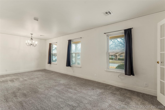 carpeted spare room featuring an inviting chandelier and a wealth of natural light