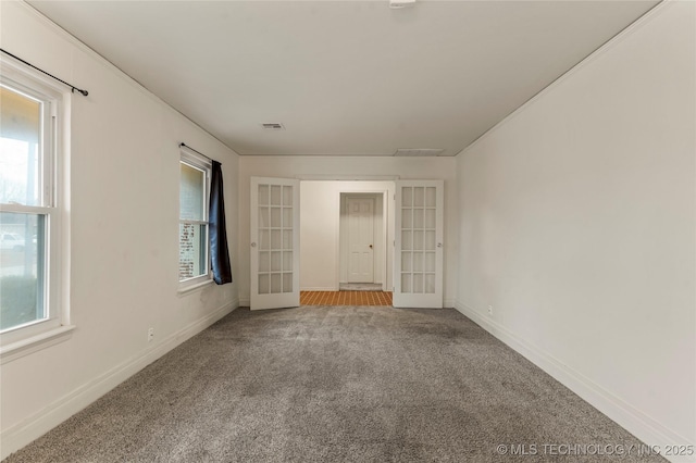 empty room with french doors, a healthy amount of sunlight, and carpet