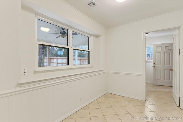 tiled spare room featuring crown molding and ceiling fan