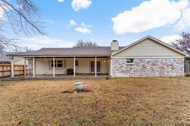 rear view of house with a patio area and a lawn