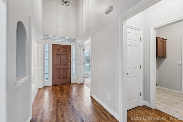 foyer entrance with a towering ceiling and hardwood / wood-style floors