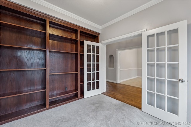 unfurnished room featuring french doors, light colored carpet, and ornamental molding